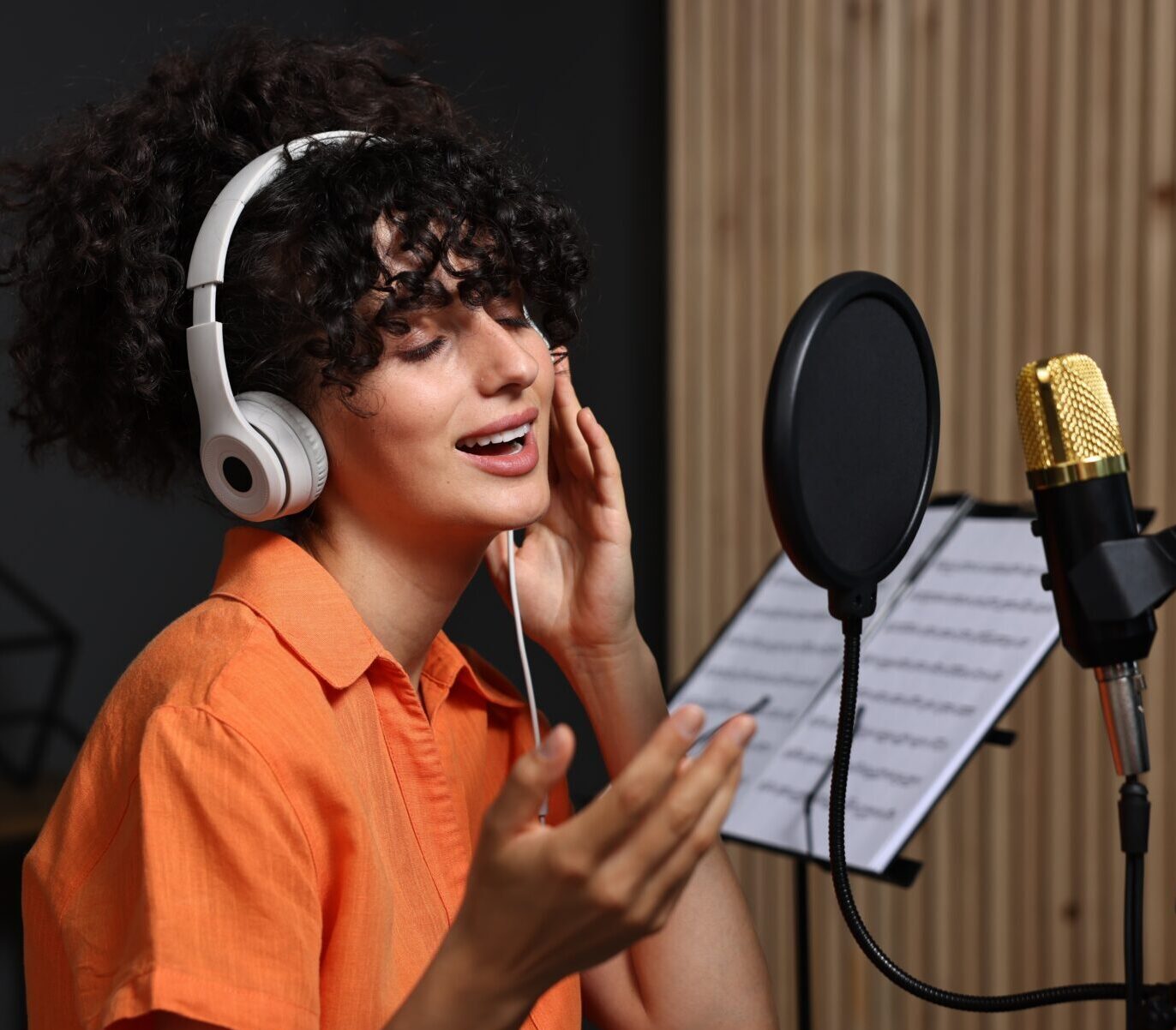 Ein Sängerin steht vor dem Microfon und sind gerade eine Song ein.